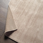 Close-up of a beige rug on a wooden floor