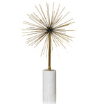 Decorative gold spike sculpture on a white cylindrical base against a white background