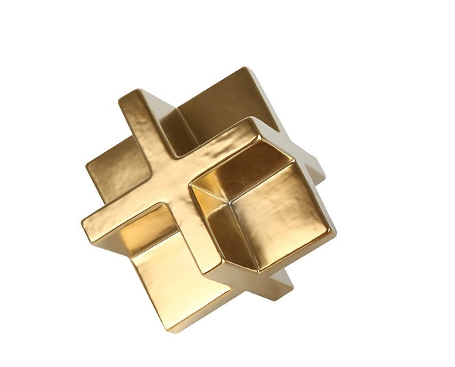 A gold-colored cubic decor object with a reflective surface