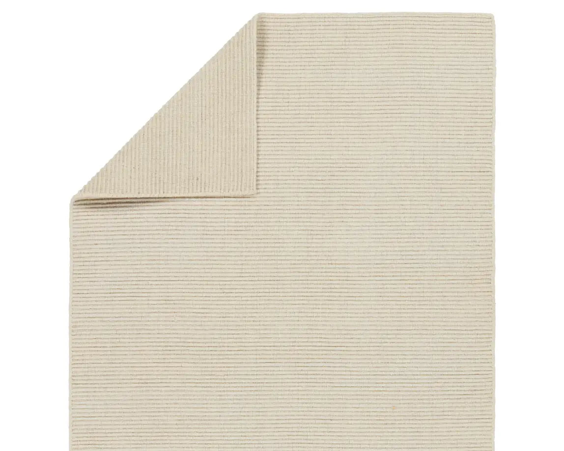A beige area rug with a textured weave, laid out flat.
