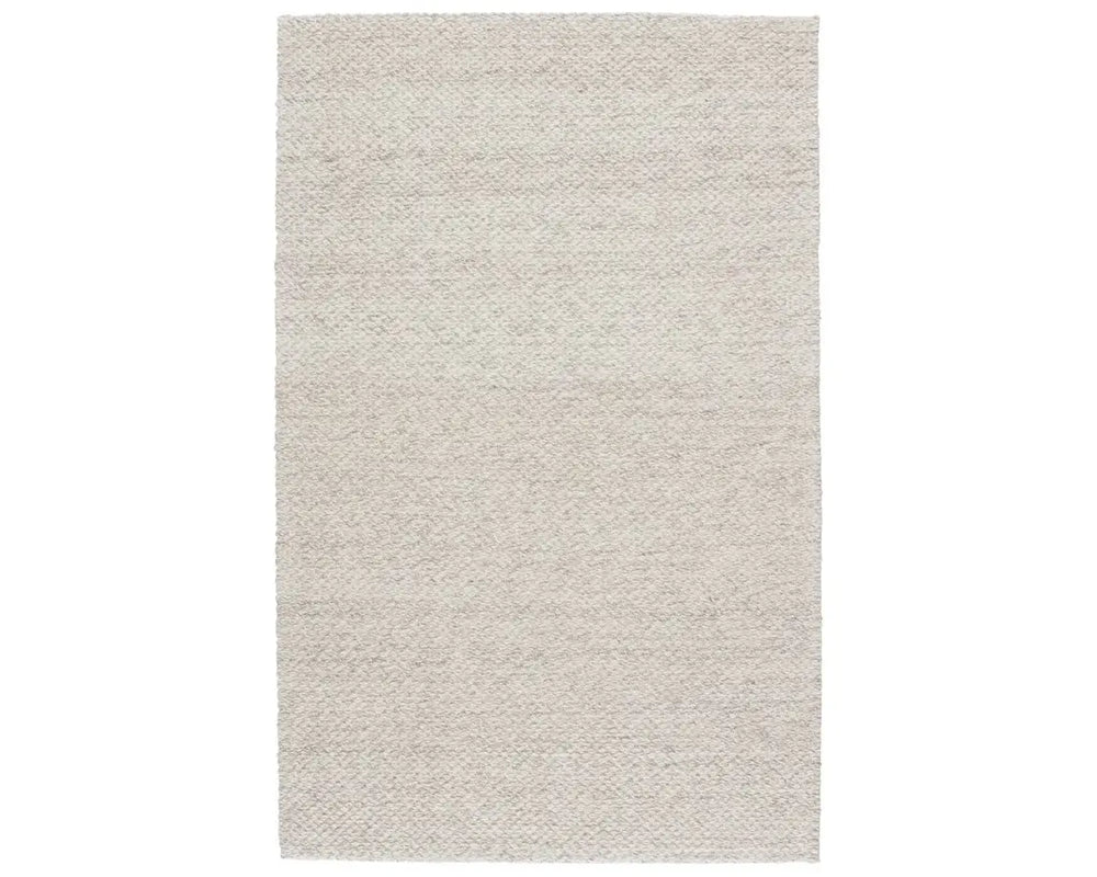 A beige, solid color wool area rug handwoven with a visible texture.
