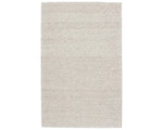 A beige, solid color wool area rug handwoven with a visible texture.