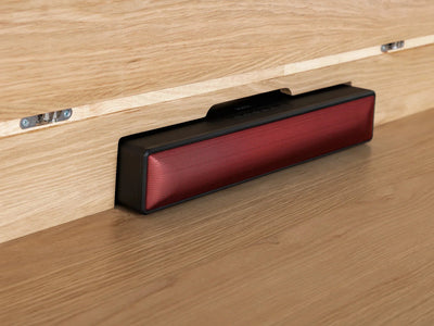 Red and black rectangular object on a wooden surface
