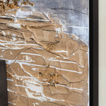 A framed abstract painting featuring various shades of taupe and gold on a canvas, predominantly in neutral tones with textured applications.