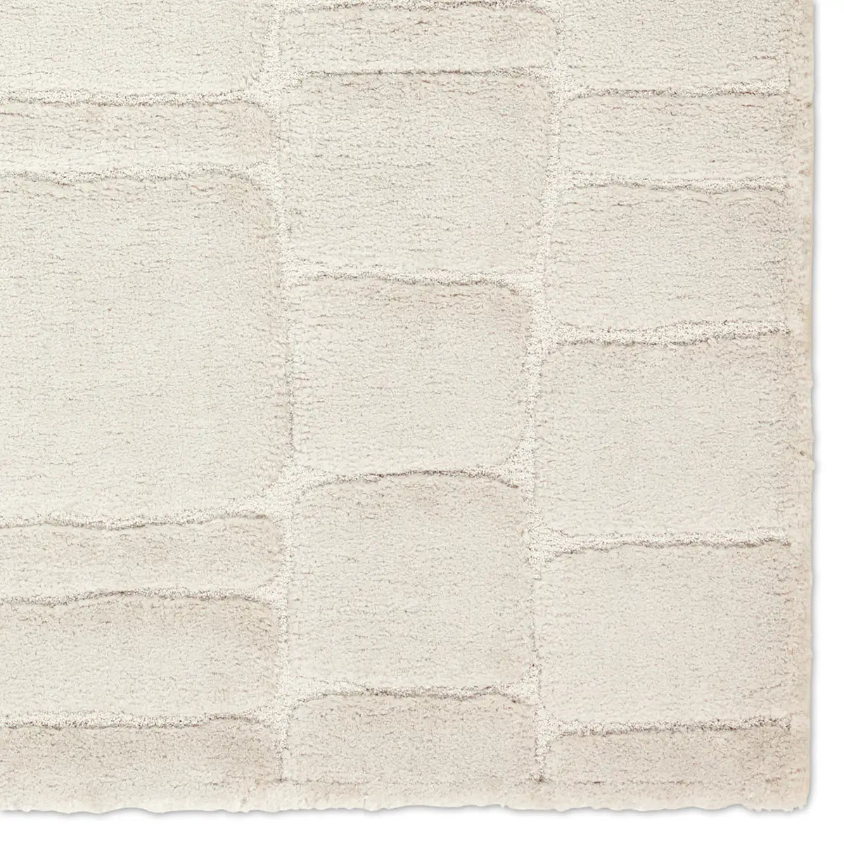 Textured beige rug with a subtle pattern on a white background