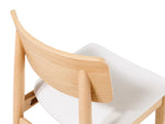 Wooden chair with white cushion on a white background