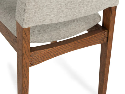 Wooden chair with gray cushioned seat on a white background