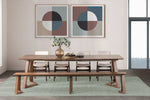 Dining room with wooden table and benches, framed abstract art on the wall.
