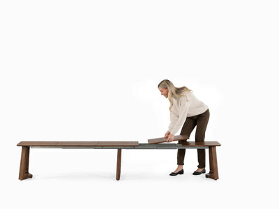Woman assembling a wooden bench on a white background