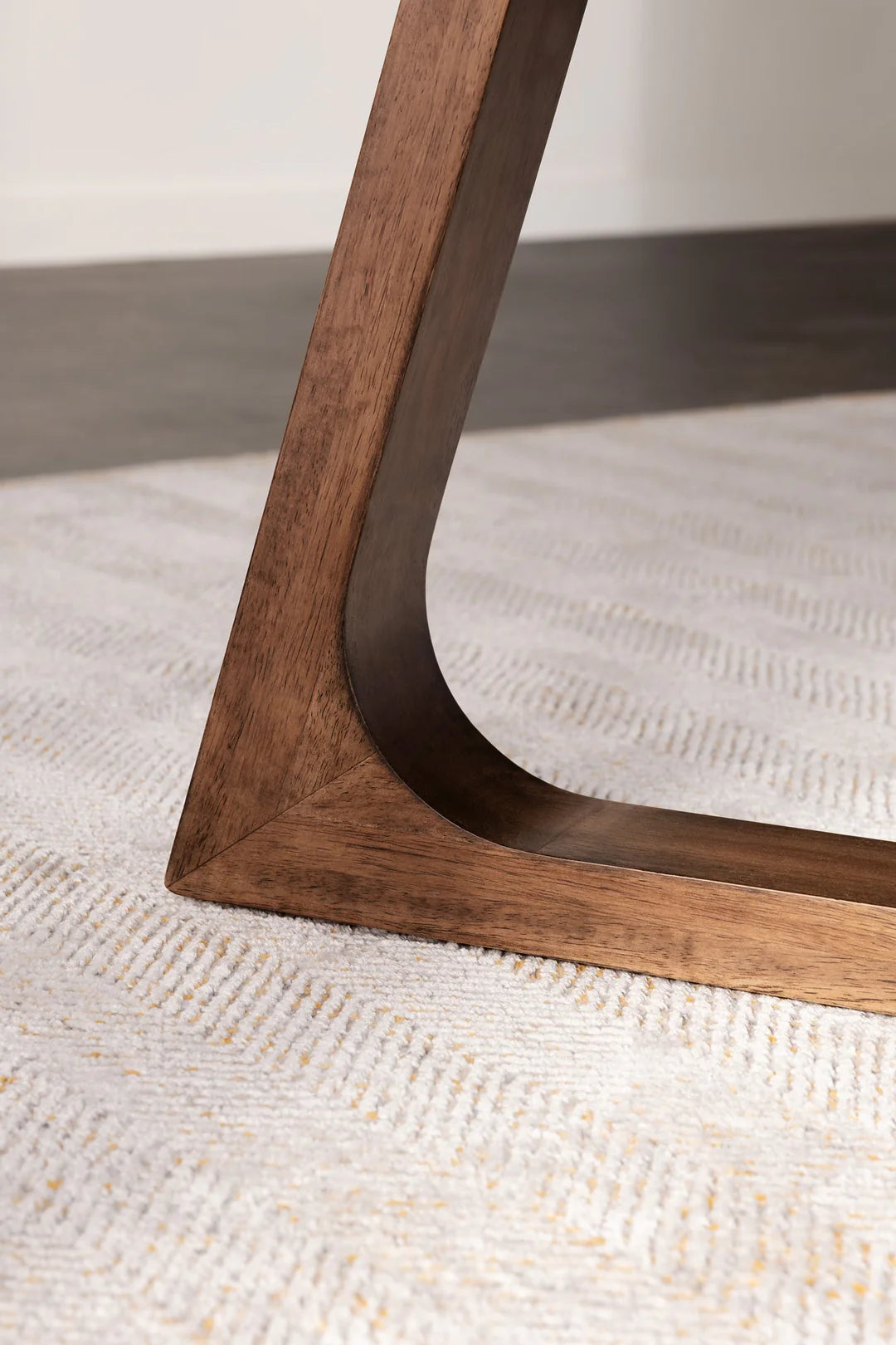 Close-up of a wooden chair leg on a textured surface