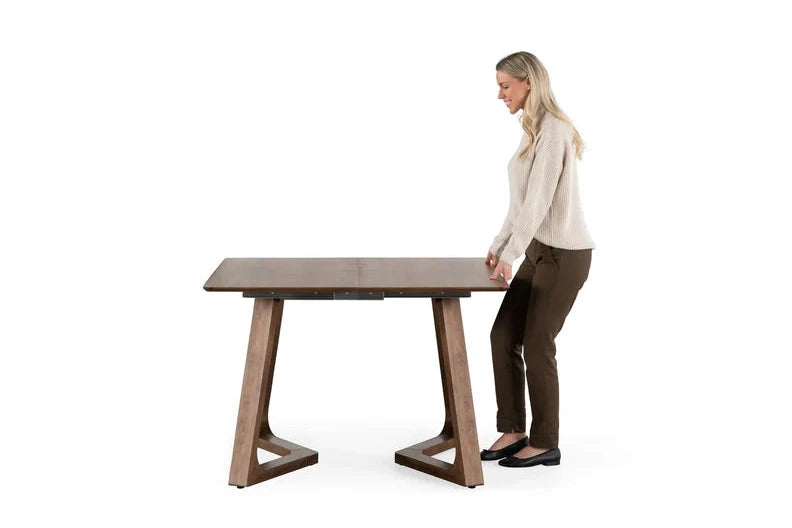 Woman standing next to a wooden table on a white background