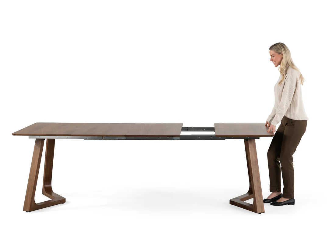Woman standing next to a large wooden table on a white background