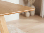 Close-up of a wooden table corner with a blurred background