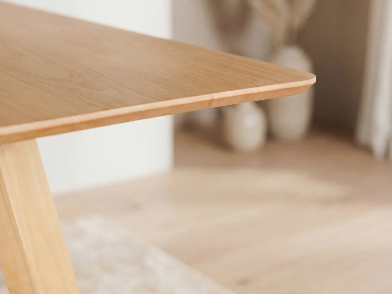 Close-up of a wooden table corner with a blurred background