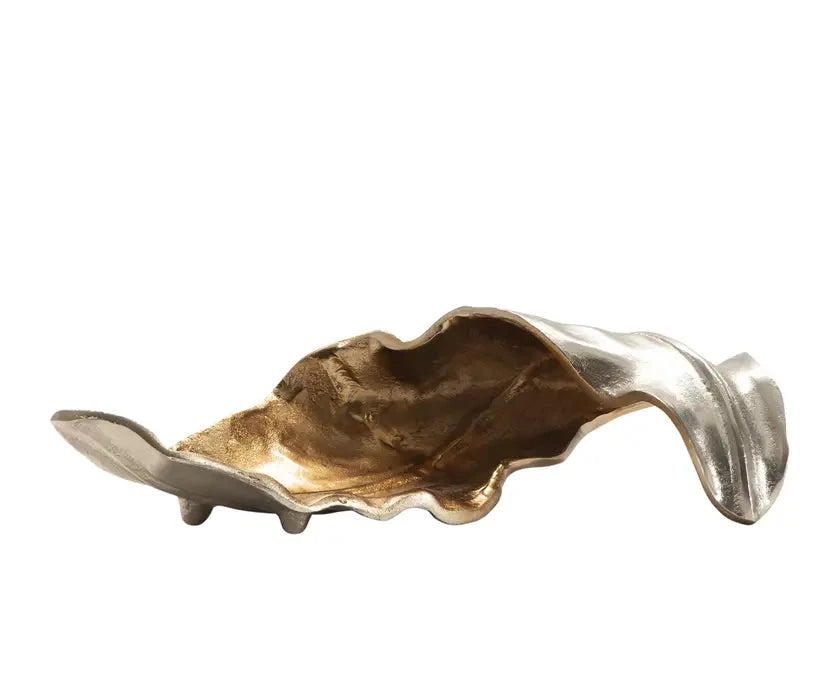 A decorative metallic object with a gold and silver finish, displaying an organic, wave-like form.