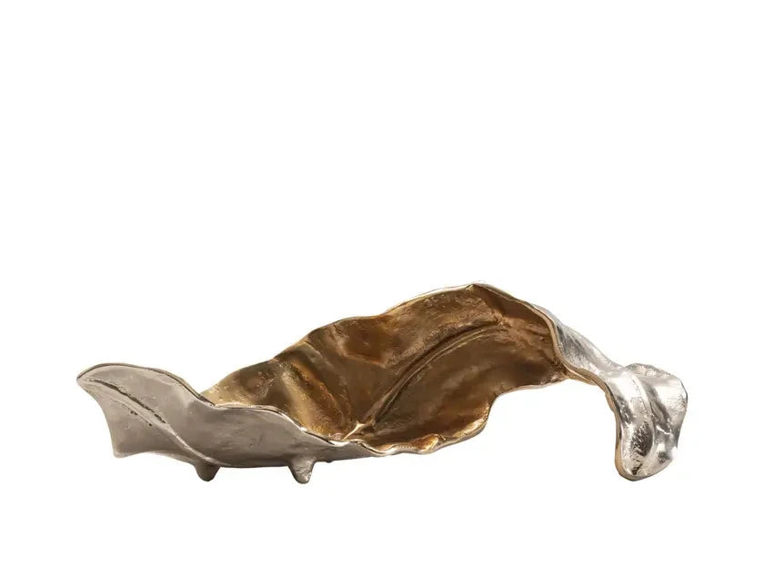 A decorative metallic object with a gold and silver finish, resembling a stylized leaf or wave.
