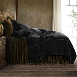 Bed with dark comforter and pillows in a bedroom setting
