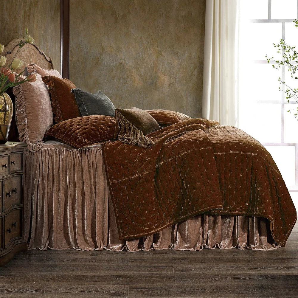 Bed with brown comforter and pillows in a room with a window and decorative elements.