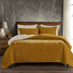 Yellow quilted coverlet on a bed with a wooden headboard in a bedroom setting.
