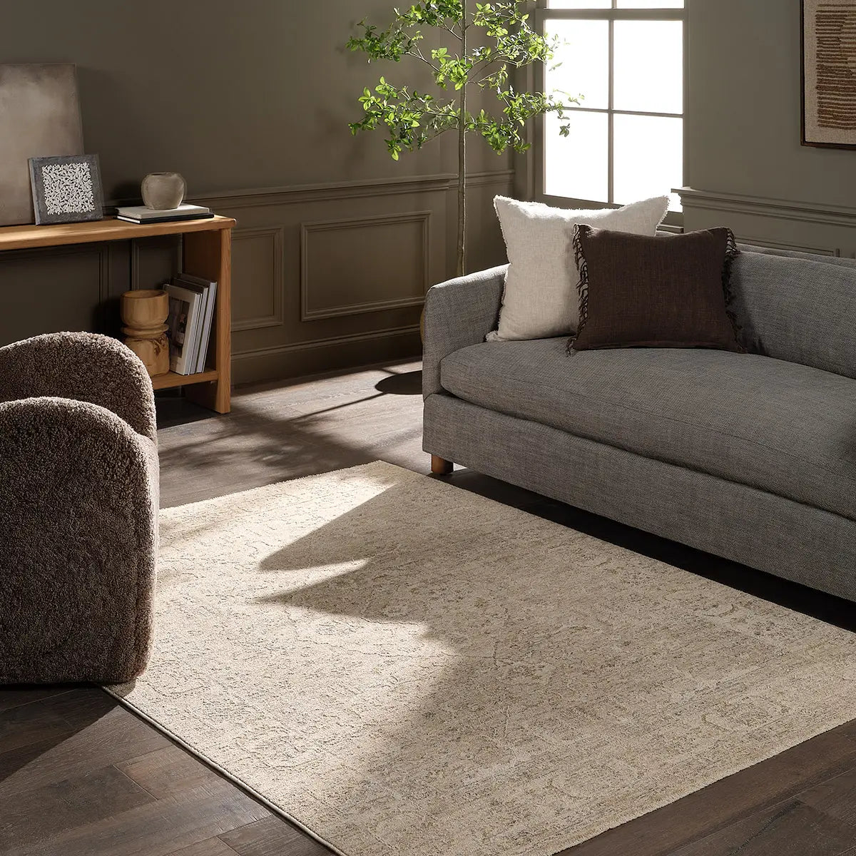 Living room with a gray sofa, armchair, and rug.