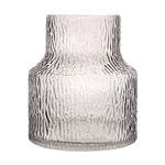 Clear glass vase with textured surface on a white background