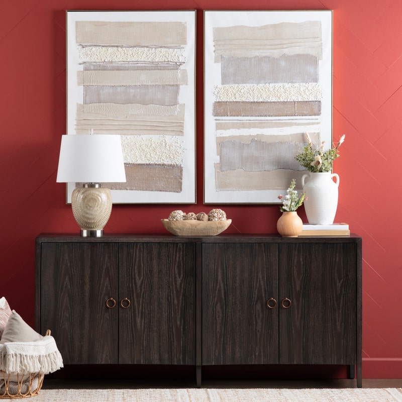Two framed abstract paintings with horizontal brush strokes in beige, brown, and white tones.