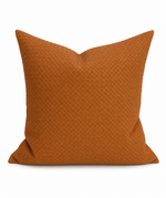 A square throw pillow in a textured rust-orange fabric with a basketweave pattern, shown against a plain white background.