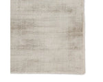 A light taupe area rug with a solid pattern, handwoven from 100% viscose.