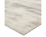 A light taupe area rug with a solid pattern, handwoven from 100% viscose.