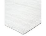 A white, solid color area rug on a plain background.