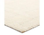 A beige area rug with a geometric pattern.