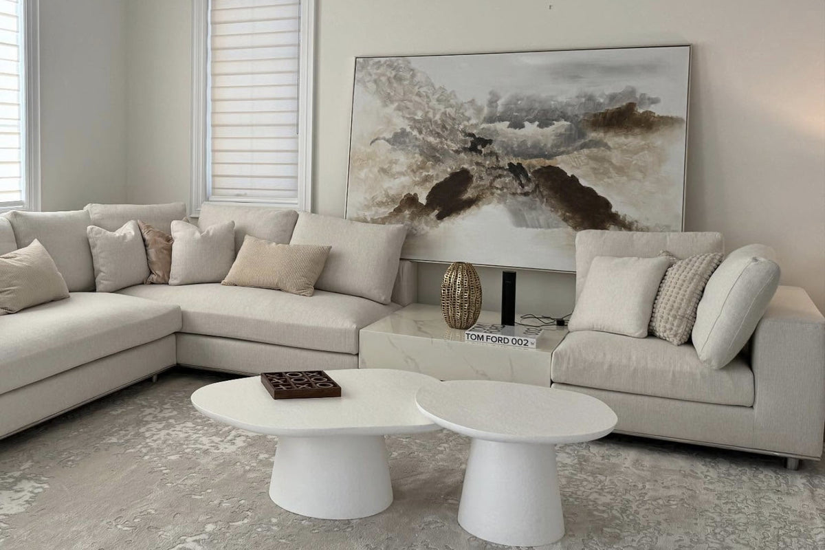 Modern living room with a sectional sofa, coffee table, and wall art.