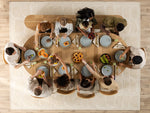 Top-down view of a group of people sitting around a wooden dining table with food.