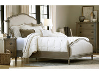Neatly made bed with white bedding in a bedroom setting.