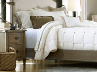 Neatly made bed with white bedding and pillows in a bedroom setting.
