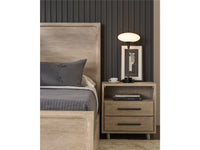 Bedroom setup with wooden headboard, nightstand, and lamp against a dark paneled wall.