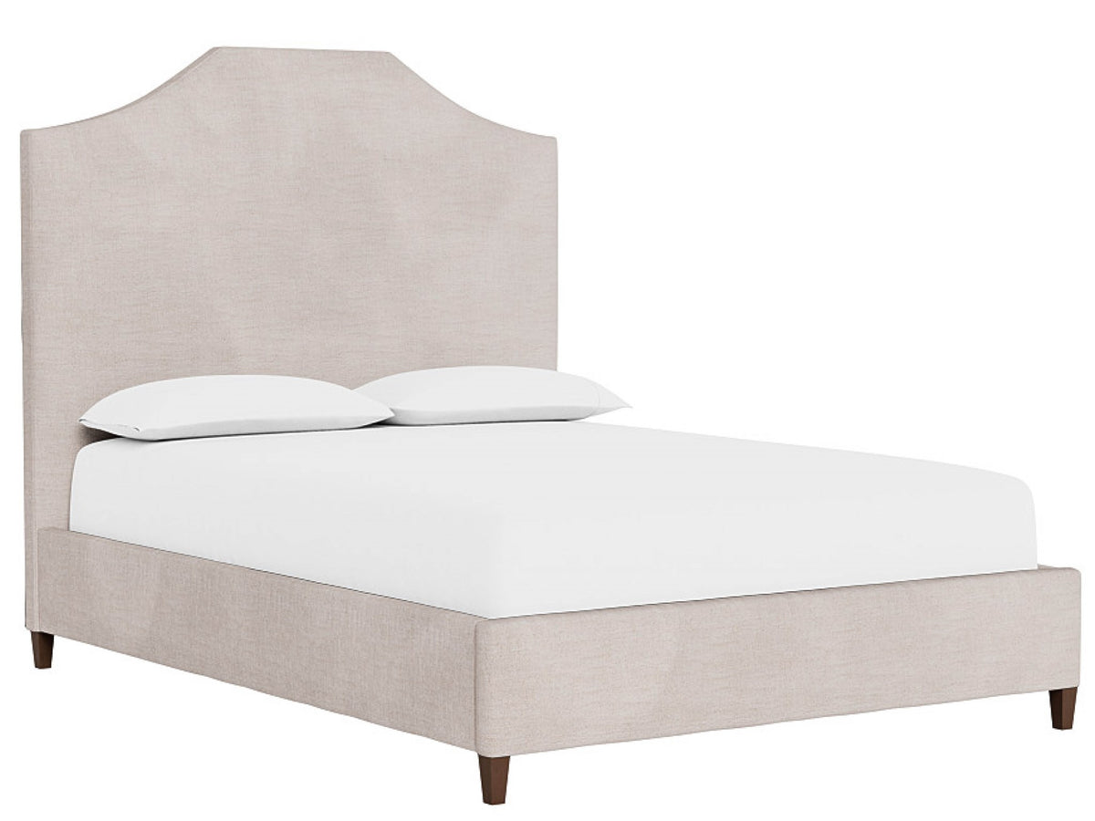 Beige upholstered bed with white bedding on a white background