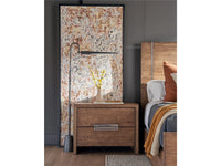 Wooden nightstand in a bedroom with a bed and decorative elements.