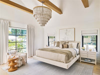 Modern bedroom with a chandelier, bed, and large windows.