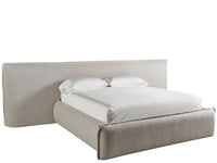 Beige upholstered bed with white bedding on a white background