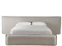 Beige upholstered bed with white bedding on a white background