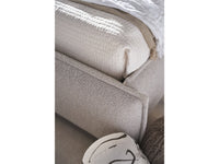 Close-up of a textured fabric surface with a white pillow and cat paw print toy.