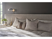 Bedroom with a bed featuring gray bedding and pillows, a nightstand with a lamp, and a gray wall.