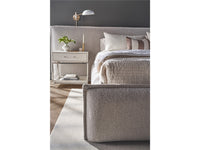 Modern bedroom with a textured bed and nightstand.