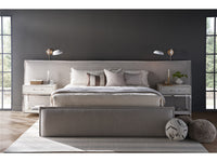 Modern bedroom with a gray upholstered bed, nightstands, and decorative pillows.