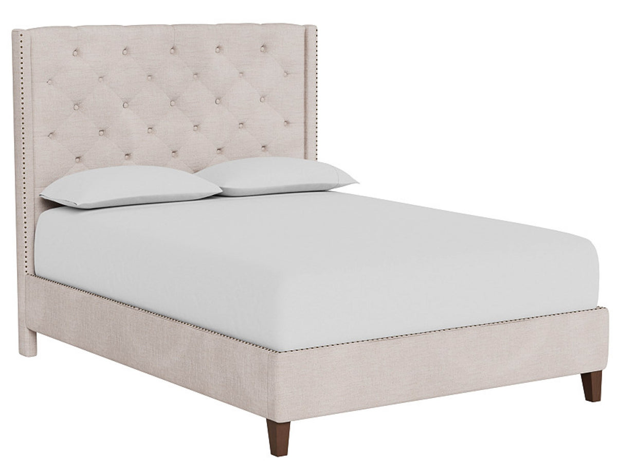 Beige upholstered bed with white bedding on a white background