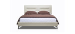 A beige upholstered headboard bed with brown leather-like fabric on the headboard and a white mattress.