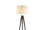 A modern style floor lamp with a black tripod base and a white lampshade, designed by Hoya Casa.