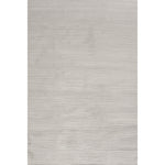 A power loomed area rug in light cream and grey colors with a polypropylene pile and jute backing.