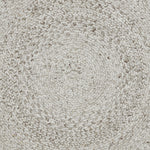 A round, beige area rug with a swirling geometric design